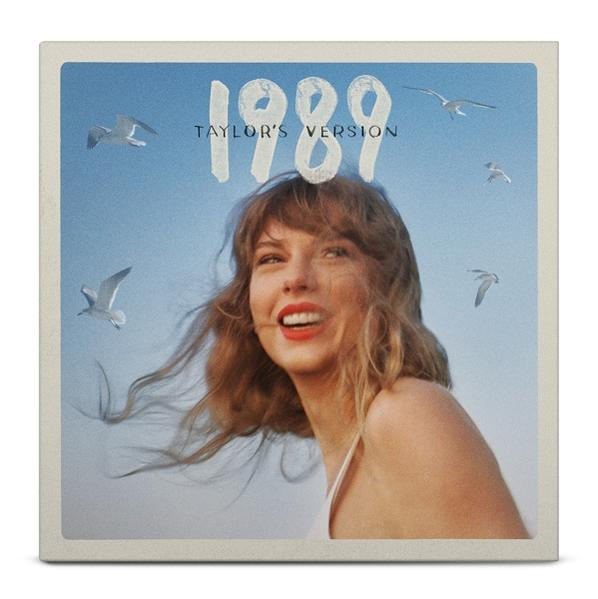 Pochette d'album de Taylor Swift, souriante, avec le texte '1989 Taylor's Version' et des mouettes volantes.