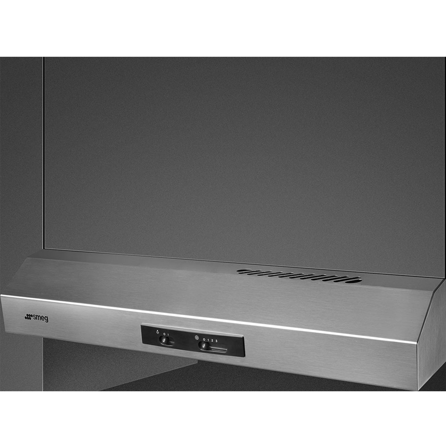 Cappa Smeg in acciaio inossidabile. Montata su una parete grigio scuro. Comandi visibili.