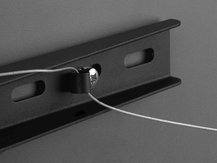 Nahaufnahme einer schwarzen Metallhalterung mit Schraube und Draht. Die Halterung befindet sich an einer grauen Wand.