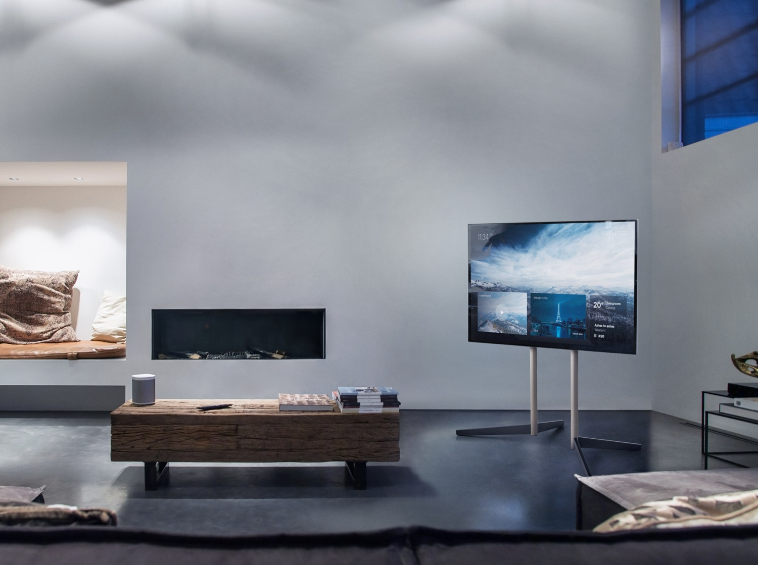 Modernes Wohnzimmer mit großem Fernseher, Holztisch, Kamin und eingebauter Sitzecke mit Kissen.