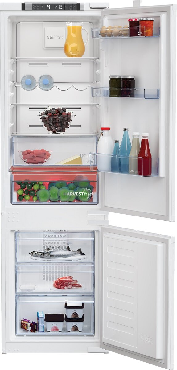 Biała lodówka Beko, otwarta z przegródkami, w tym zamrażarką i półkami z jedzeniem.