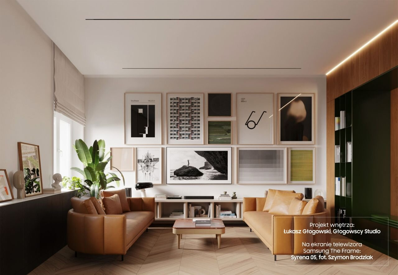 Salon z grafikami na ścianie, dwiema brązowymi sofami i drewnianą podłogą.