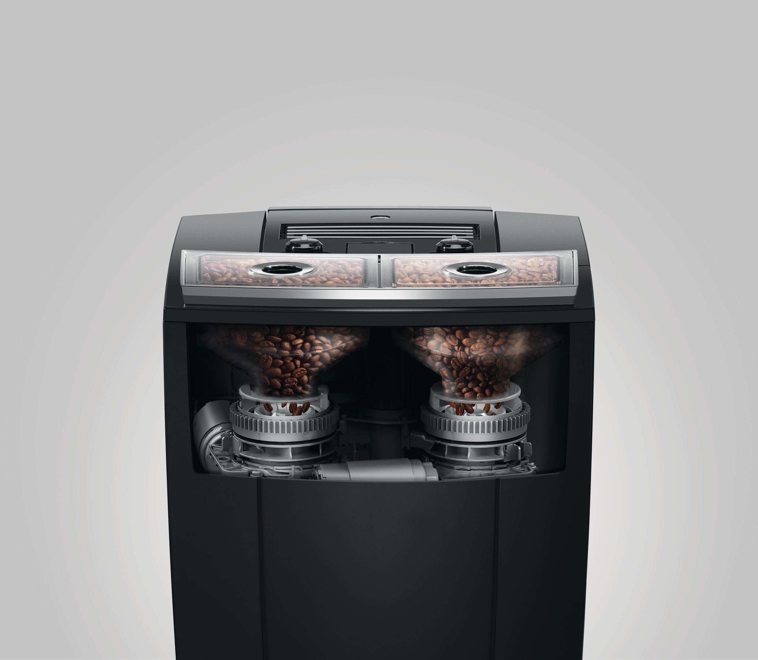 Ein schwarzer Kaffeemaschinenausschnitt zeigt Bohnenbehälter und Mahlmechanismen. Der Hintergrund ist weiß.