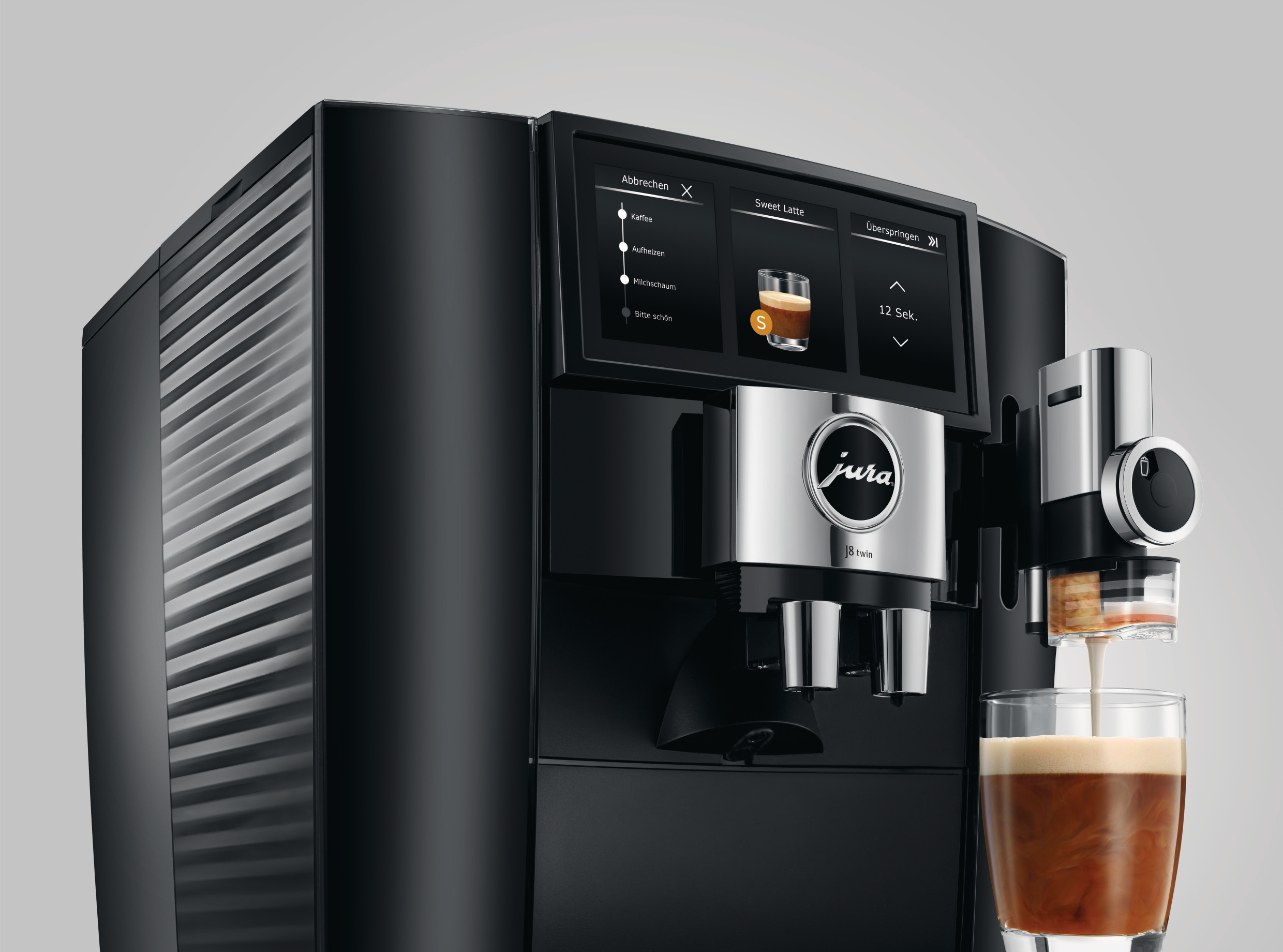 Eine schwarze Jura Kaffeemaschine gibt Kaffee in ein Glas aus. Ein Bildschirm zeigt Getränkeoptionen.