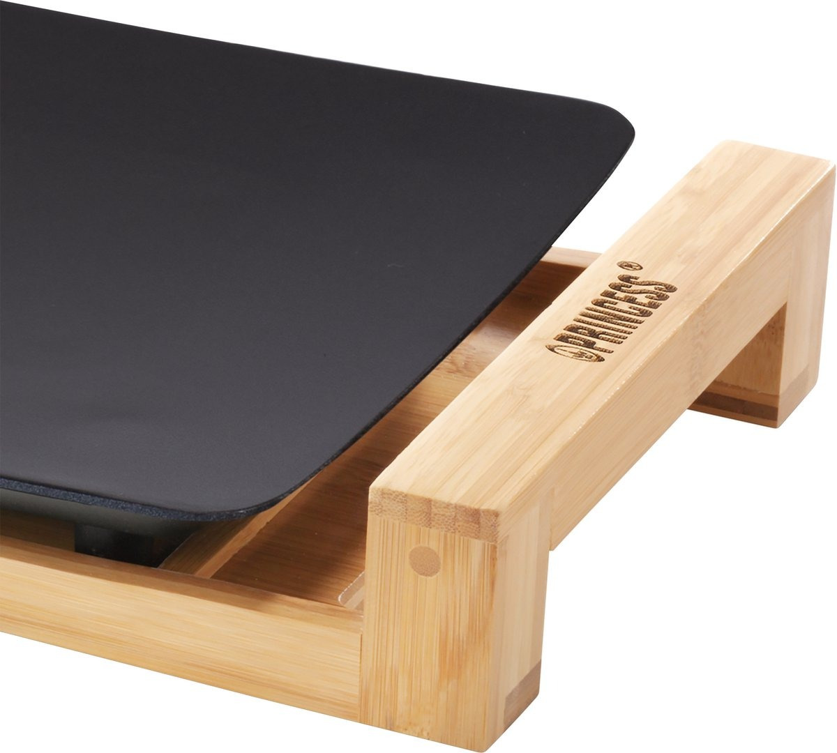 Close-up of a black griddle on a wooden stand. Griddle is slightly angled upwards.