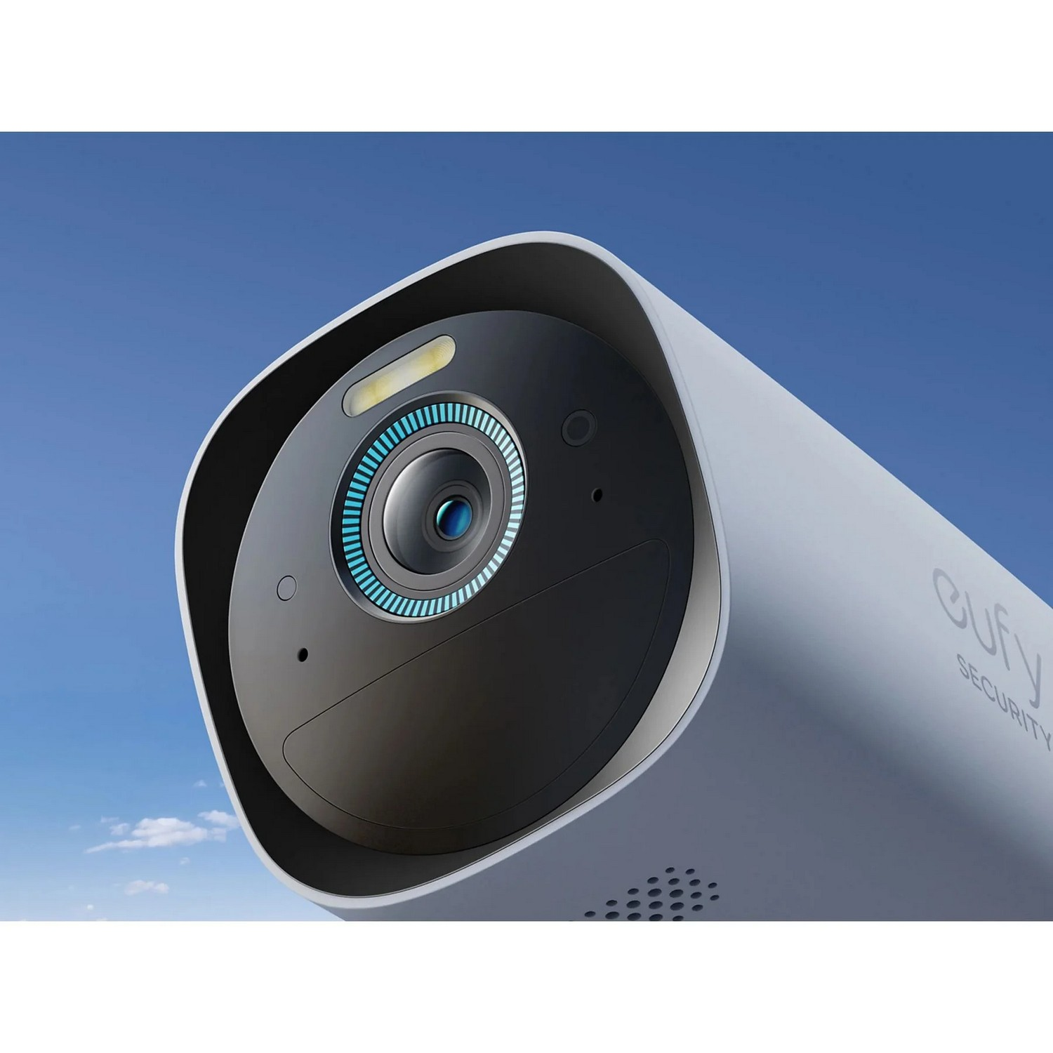 White security camera with a dark lens and blue sky background. The Eufy logo is visible.