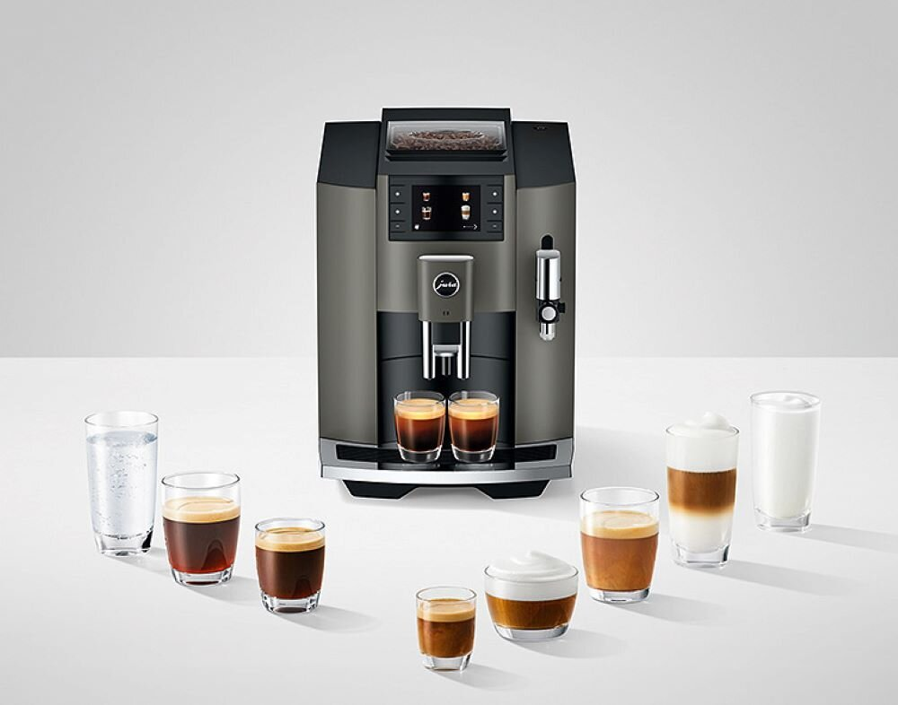 Ciemnoszara maszyna do kawy z różnymi napojami kawowymi w szklankach. Na wystawie znajduje się osiem różnych napojów.