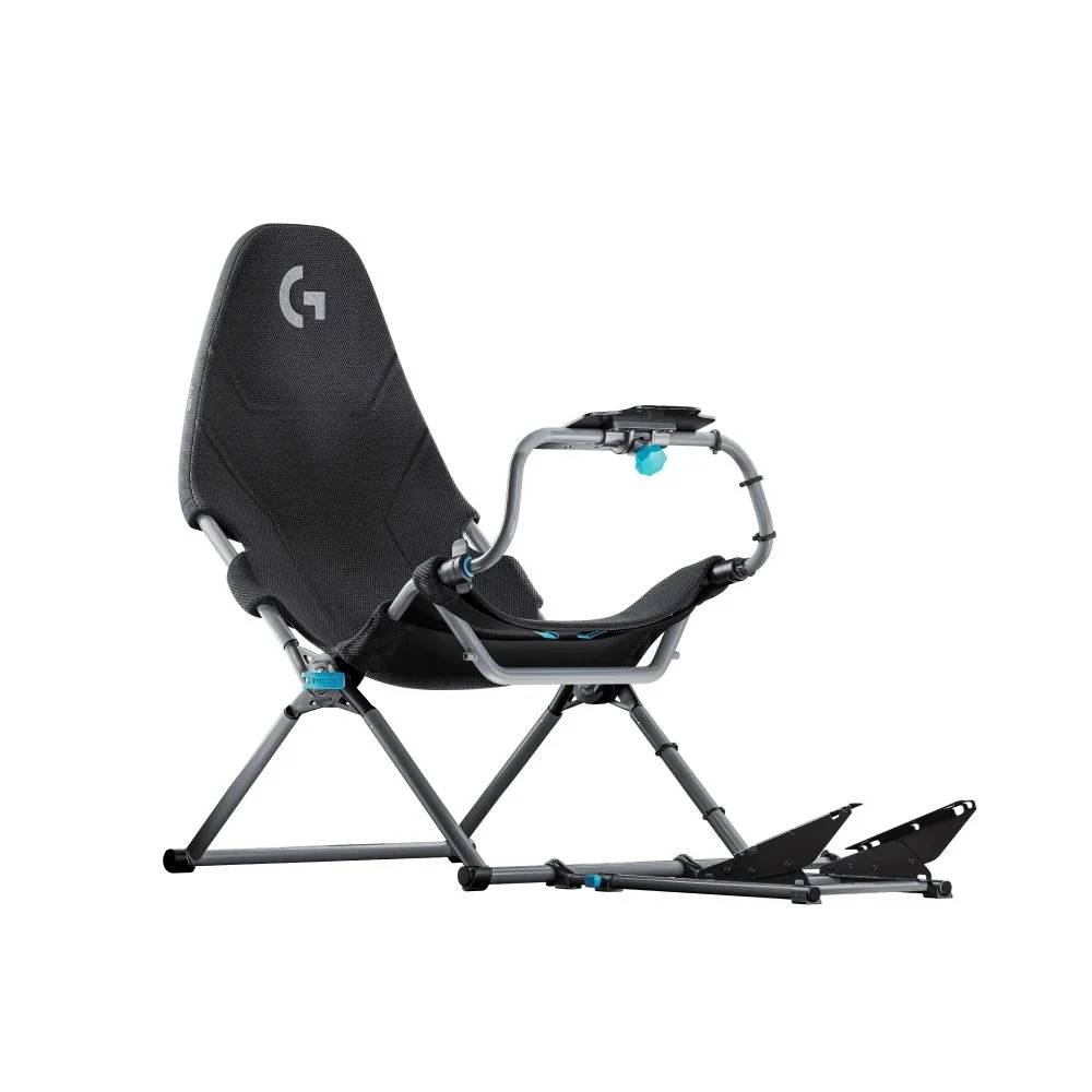 Una silla de juego negra con marco, reposabrazos y reposapiés. La silla está en ángulo y lista para usar.