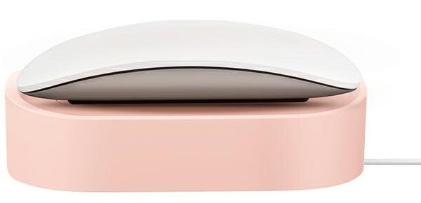 Biała mysz Apple Magic na różowej podstawie ładującej. Dołączony biały kabel. Tło jest białe.