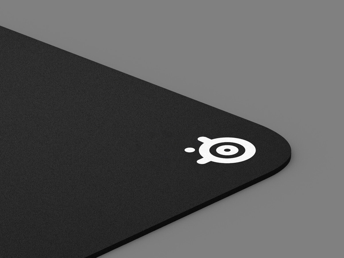 Czarny róg podkładki pod mysz z białym logo koła w kole, na szarej powierzchni.
