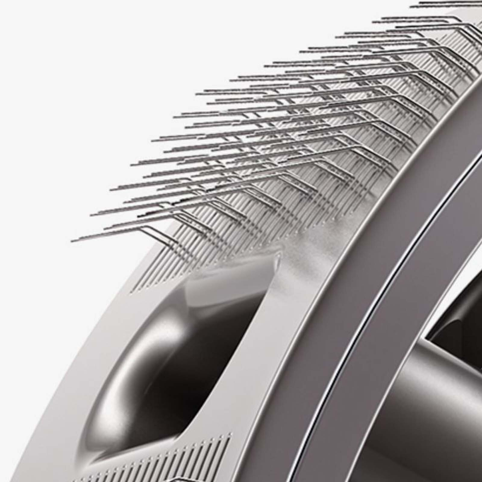 Zbliżenie metalowego ostrza maszynki do włosów, z wieloma zębami. Białe tło.