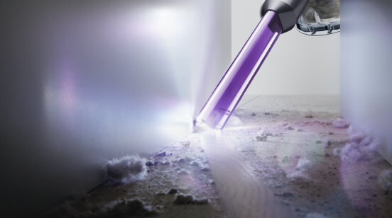 Dysza odkurzacza czyszcząca narożnik, pokazująca kurz i zanieczyszczenia.