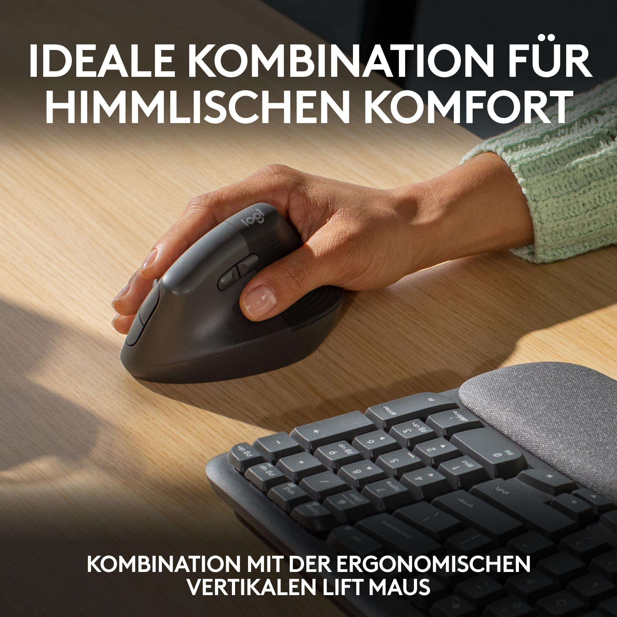 Eine Hand hält eine graue vertikale Maus. Eine Tastatur befindet sich im Hintergrund.