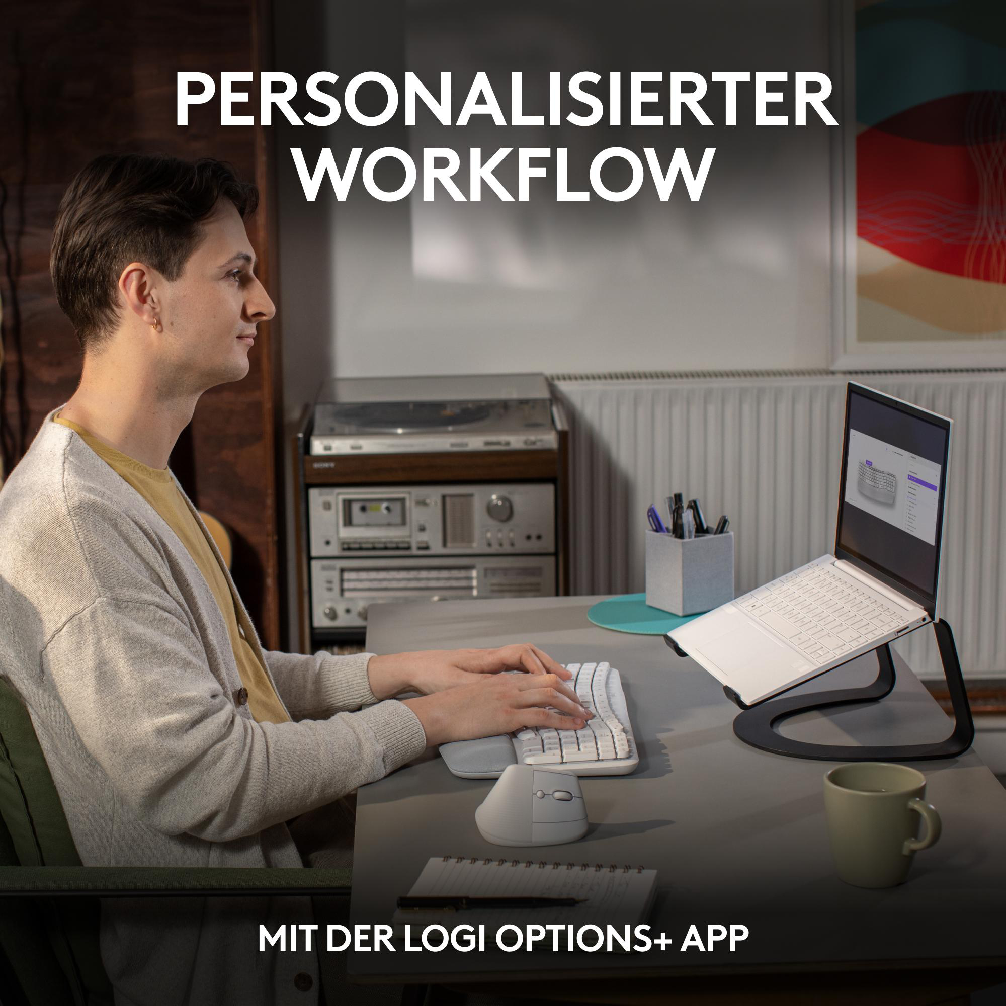 Mann tippt auf weißer Tastatur mit Maus und Laptop.