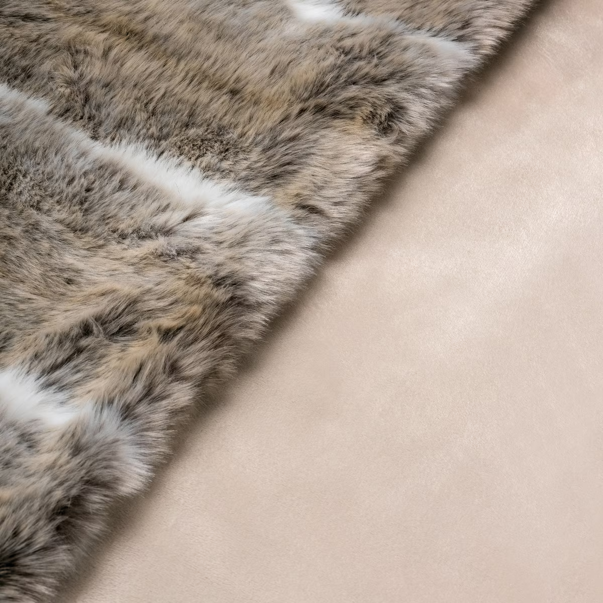 Alfombra de piel con parches blancos y una superficie beige clara.
