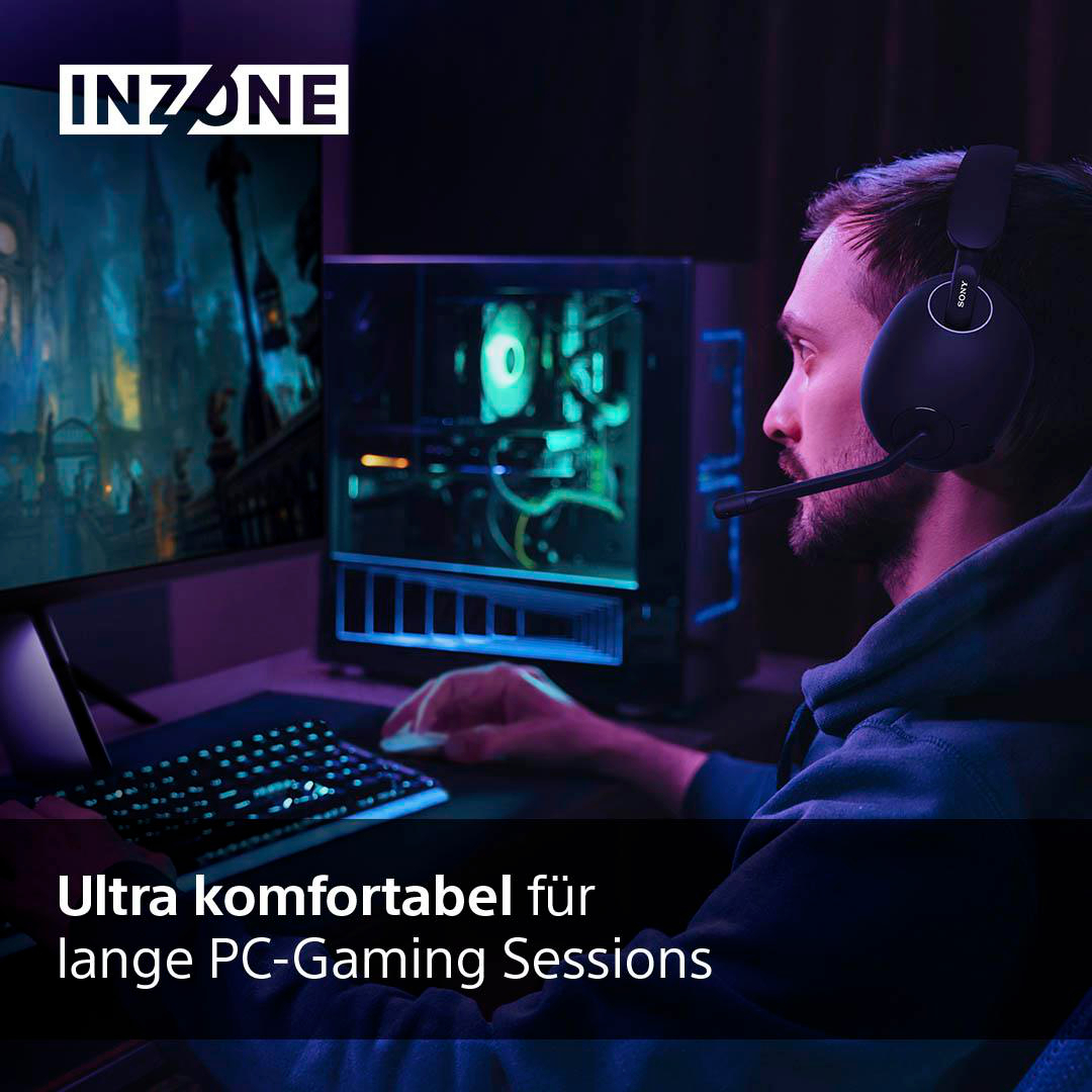 Mann mit Gaming-Headset in dunklem Raum, spielt am Computer mit Tastatur und Monitor.