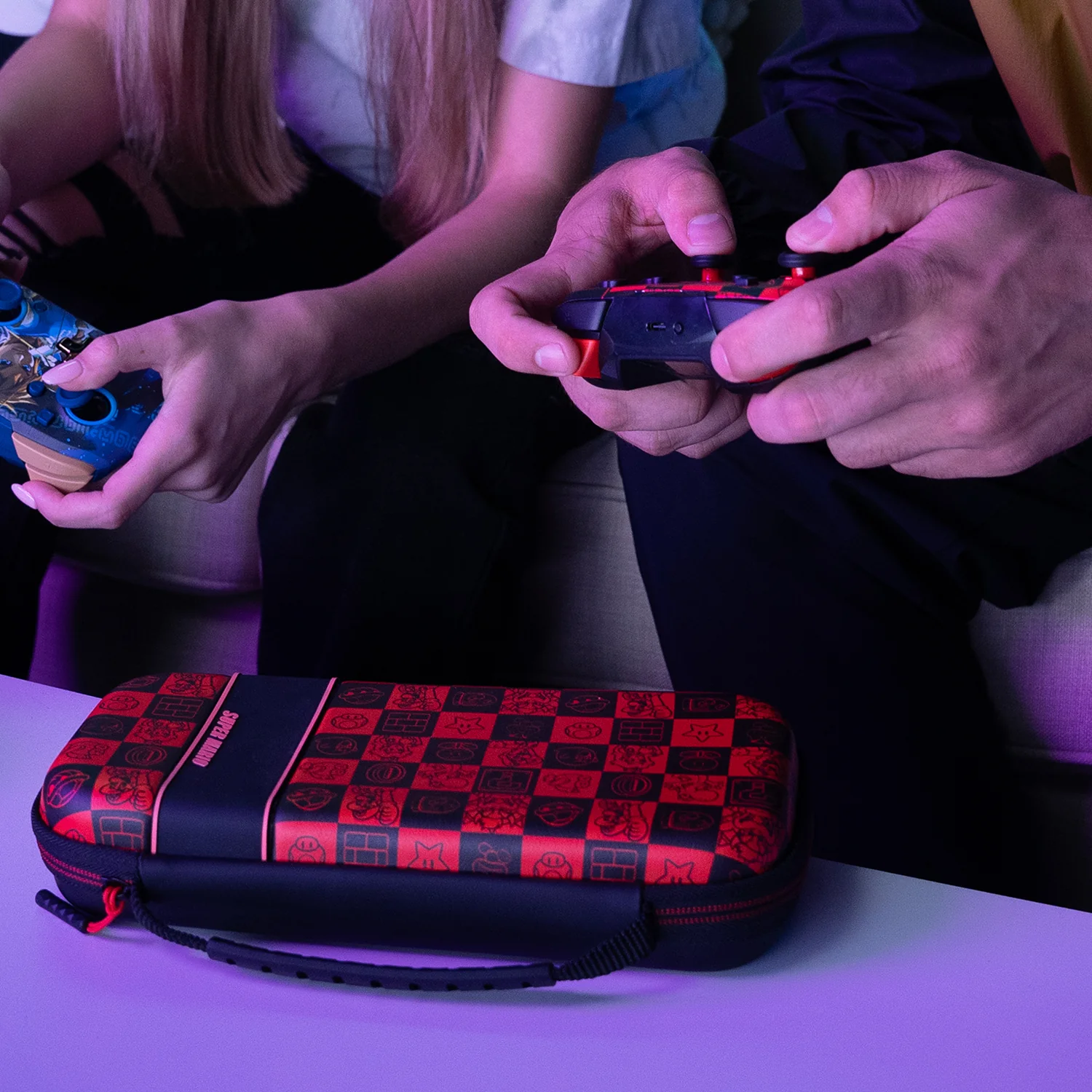 Persone che giocano. Mani che tengono controller e custodia Super Mario.