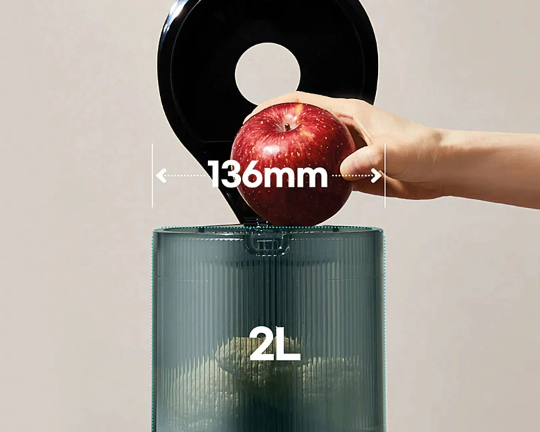 Eine Hand lässt einen roten Apfel in einen zylindrischen Behälter fallen. Abmessungen: 136 mm. Kapazität: 2L.