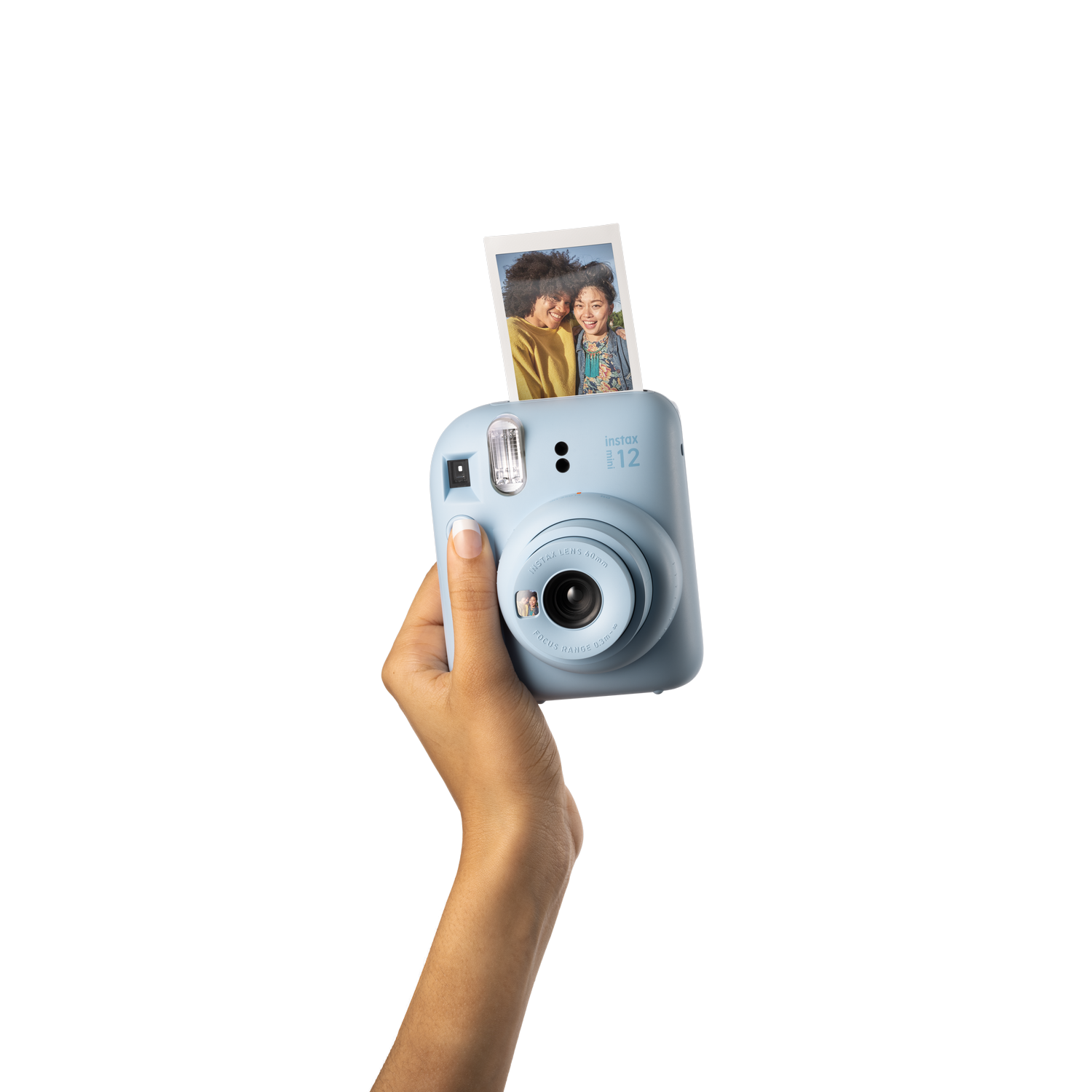 Hand die een blauwe Instax-camera vasthoudt met een foto. Zwarte achtergrond.