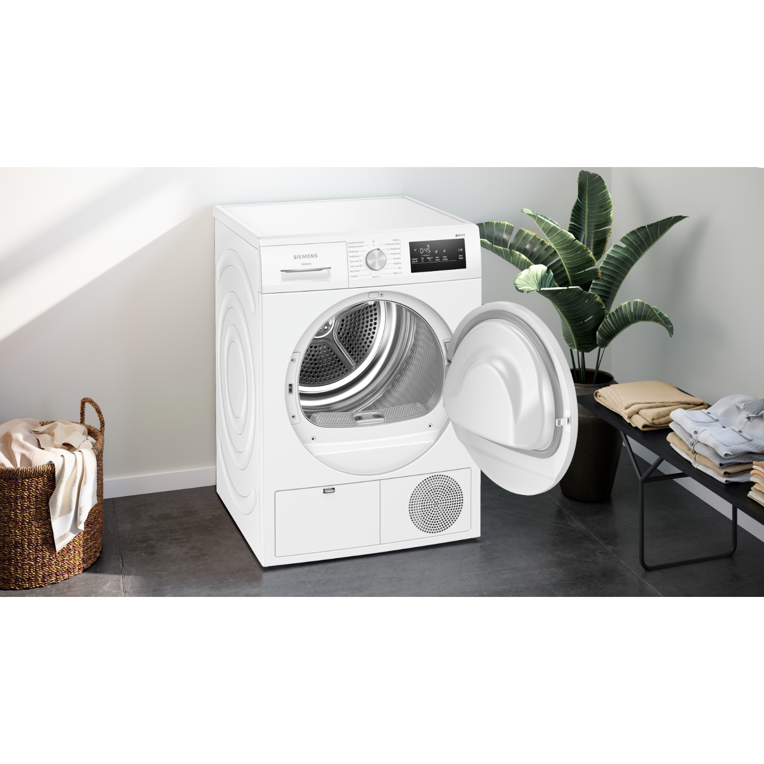 Witte Siemens droger met open deur, trommel binnenin zichtbaar. Wasmand en plant zijn in de buurt.