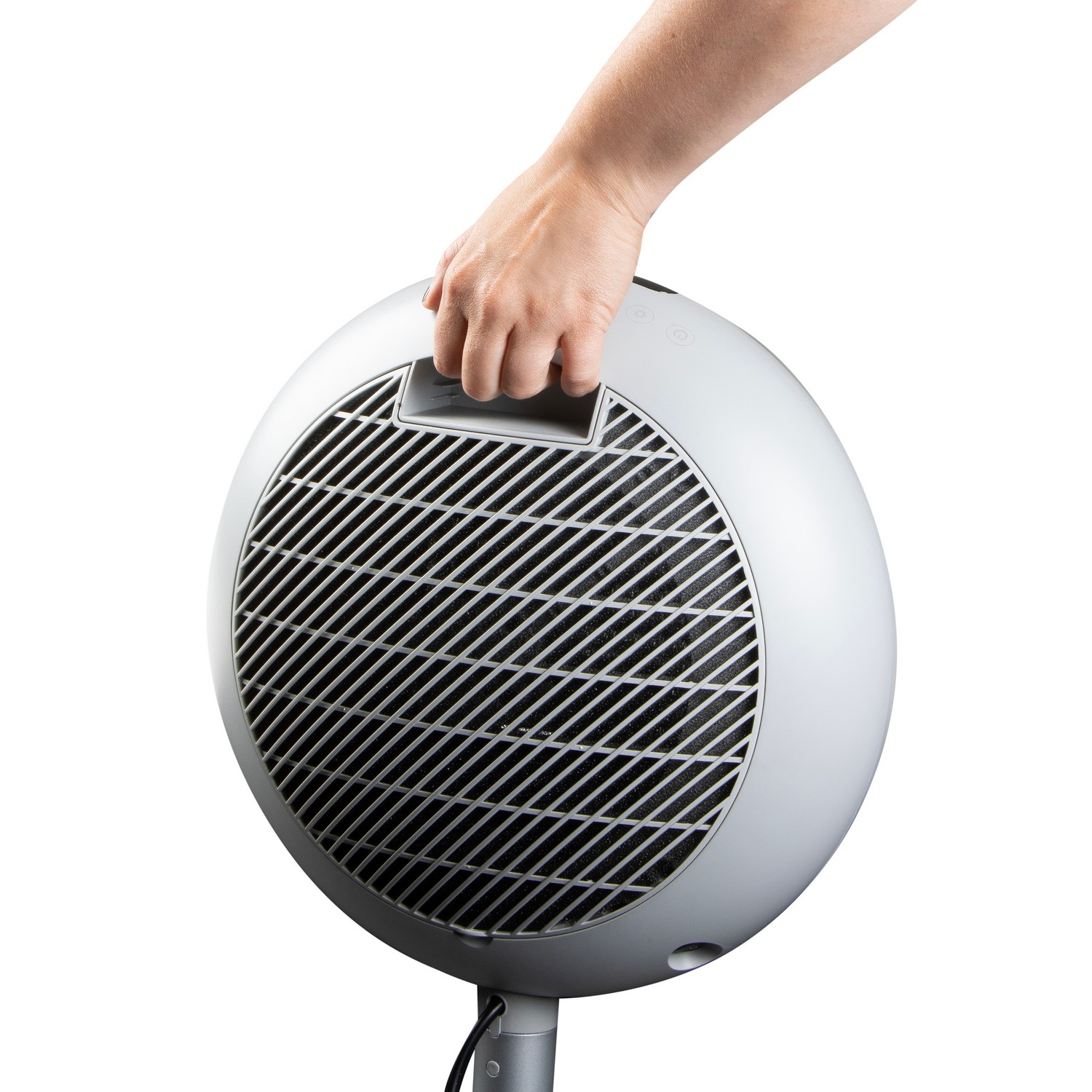 A person holding a silver, round fan. The fan has a black grill and a handle.