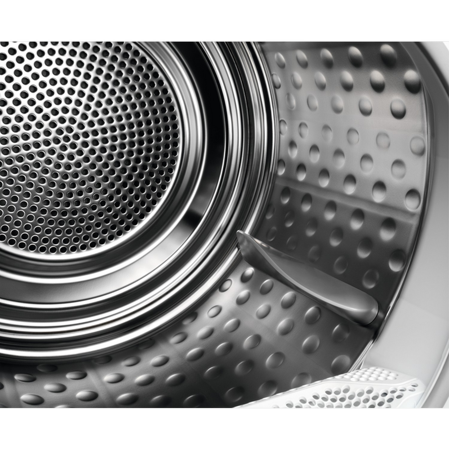 Inside a silver washing machine drum.