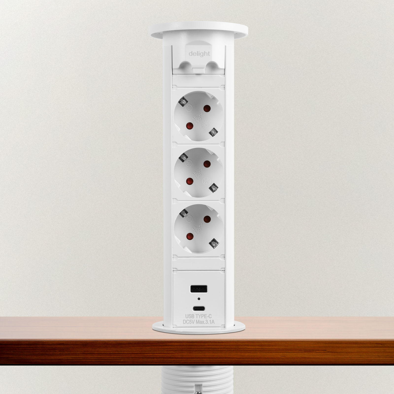 Fehér felugró elektromos aljzat és USB-töltő fa felületen, világos háttér előtt.