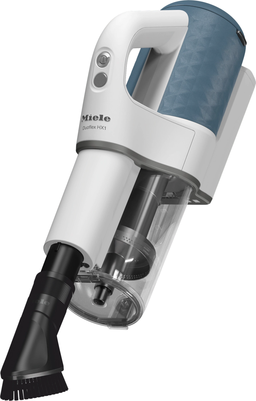 Un aspirateur à main blanc et bleu, incliné sur un fond noir. L'aspirateur a plusieurs parties.