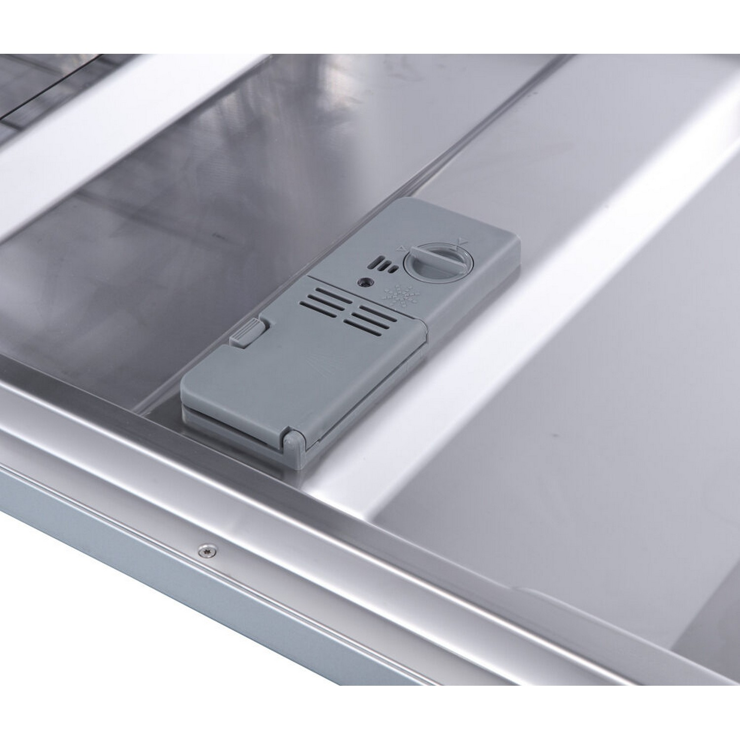 Close-up of the dishwasher soap dispenser. Gray plastic with buttons and a dial, inside a silver dishwasher.