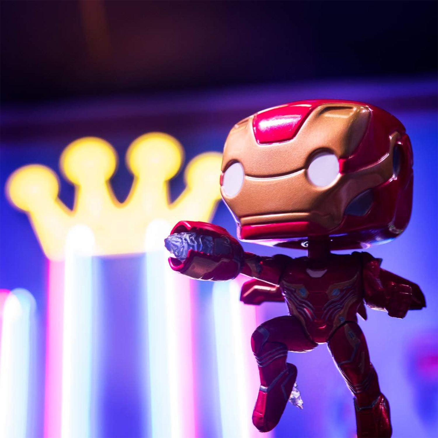 Statuetta di Iron Man con una luce a forma di corona sullo sfondo.