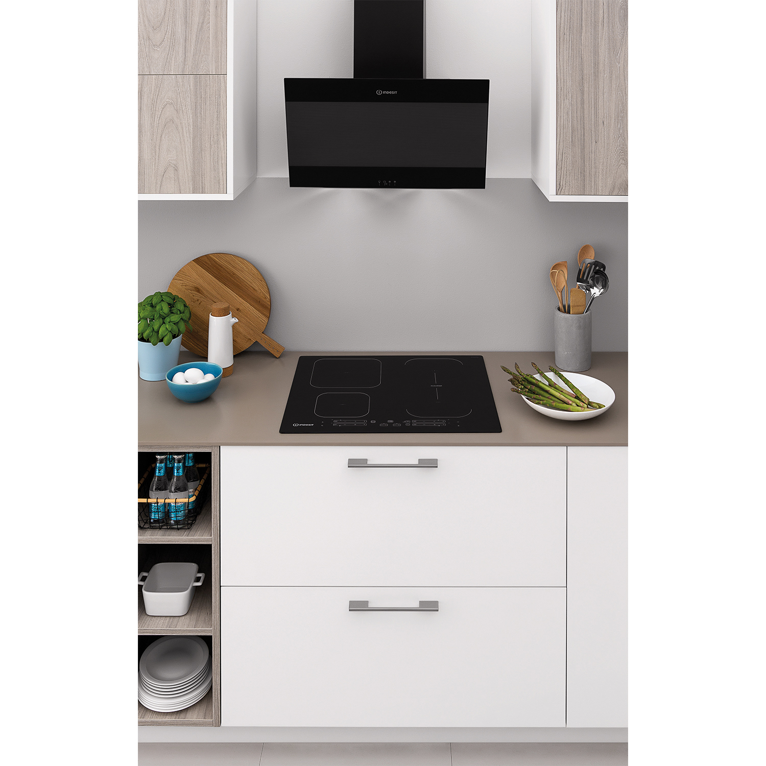 Una cucina con mobili bianchi, piano di lavoro grigio, piano cottura e cappa neri.