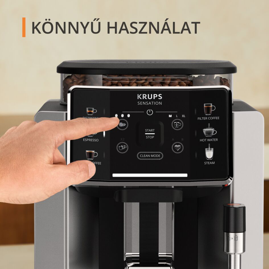 Egy személy keze megérinti a Krups kávéfőző érintőképernyőjét.