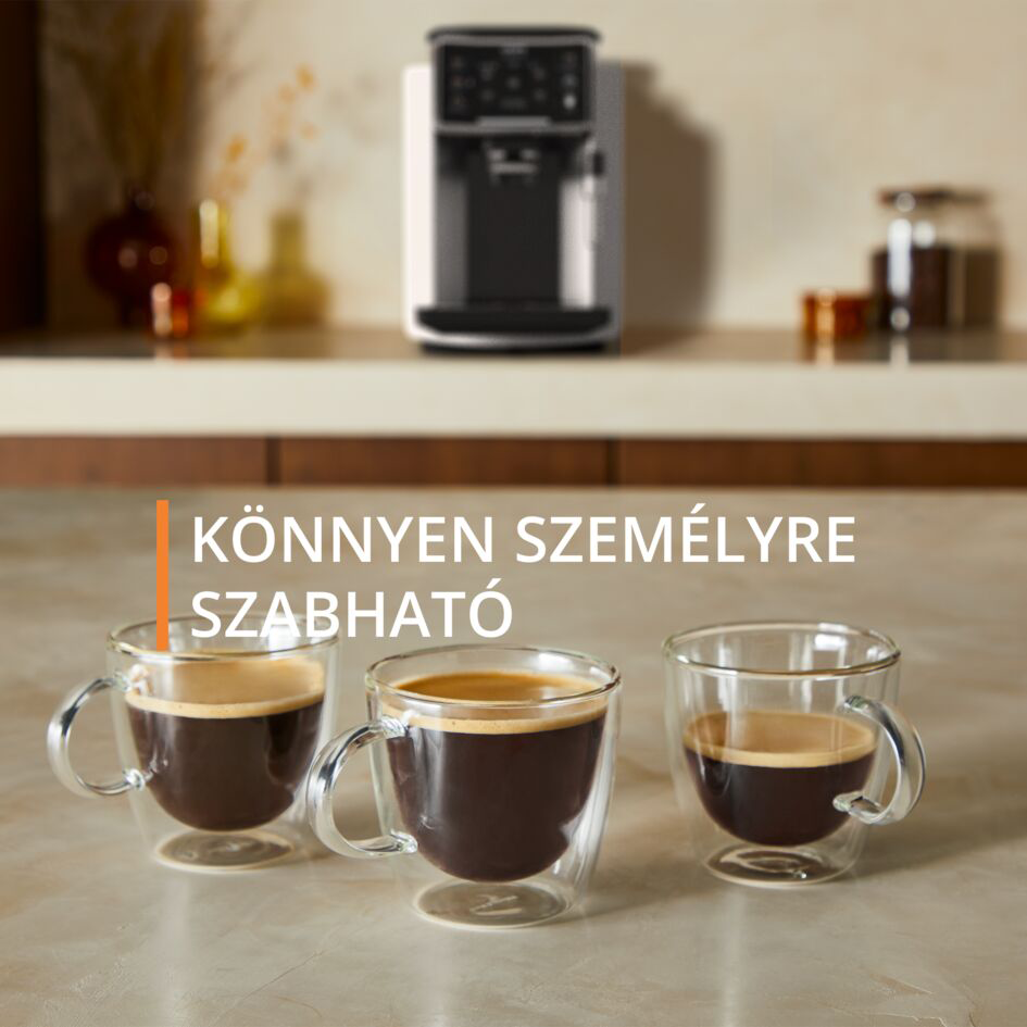 Három csésze kávé a pulton, egy kávéfőző közelében.