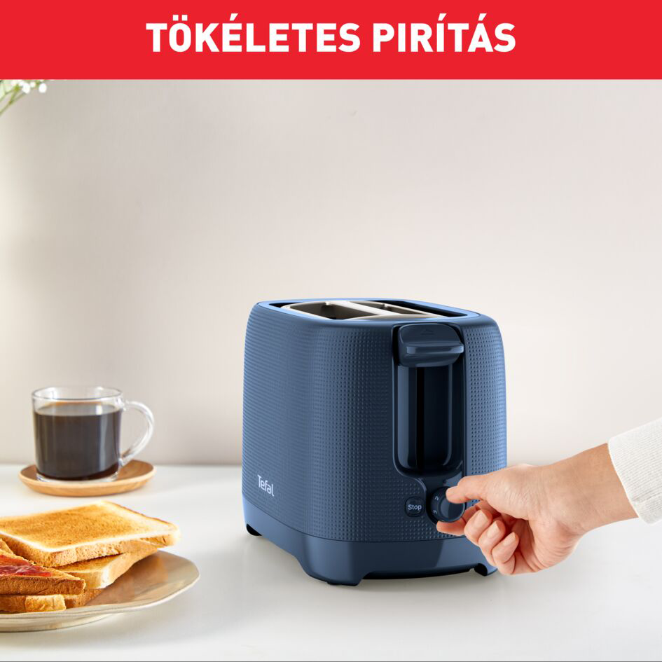 Kék kenyérpirító pirítóssal, kéz a fehér felületen gombot teker.