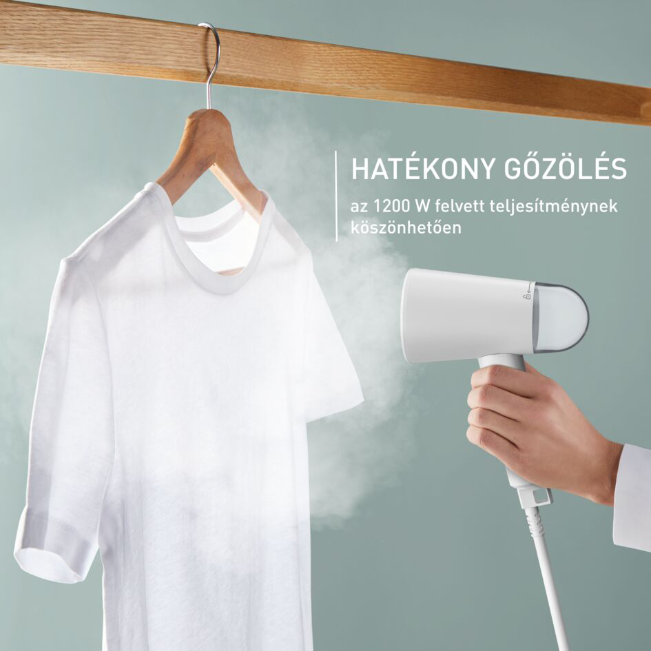Egy személy egy fehér pólót gőzöl egy vállfán, egy kézi gőzölővel. Szöveg is látható.