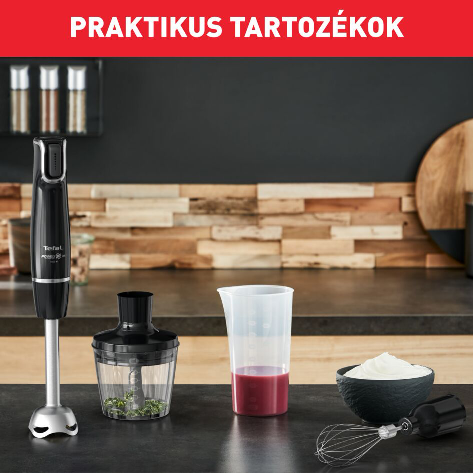Egy kézi mixer készlet több tartozékkal. Fekete pult és egy tál tejszínhabbal.