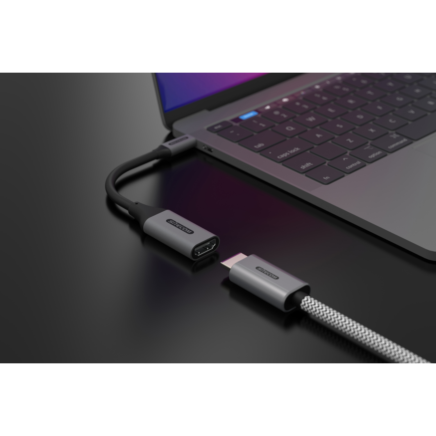 Laptop connected to an HDMI adapter via a USB-C cable. The adapter is gray.