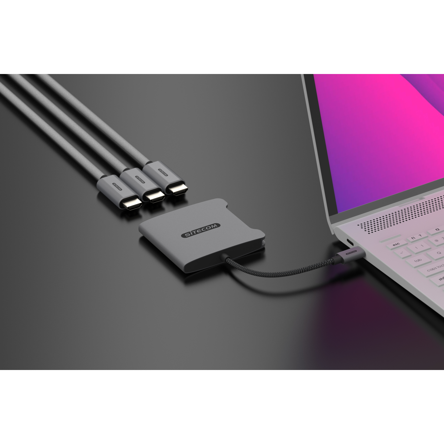 A hub connecting three gray USB-C cables to a gray hub, which is connected to a laptop.