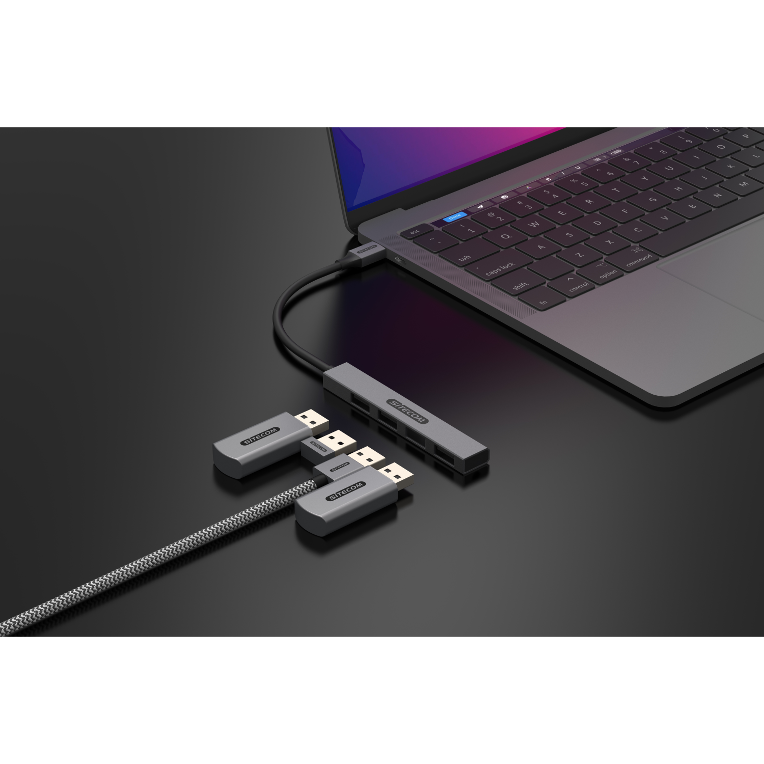 Laptop connected to a USB hub with USB drives. All in dark grey.