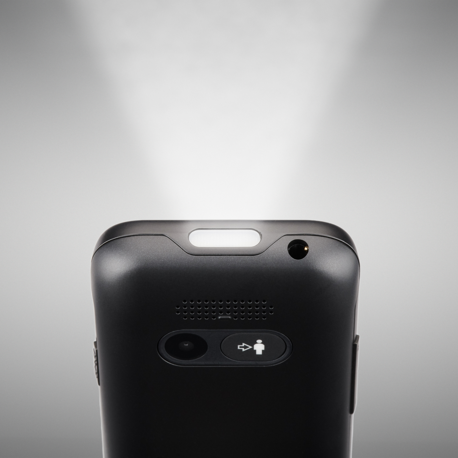 Close-up of a black device with a light and buttons, illuminated from above.