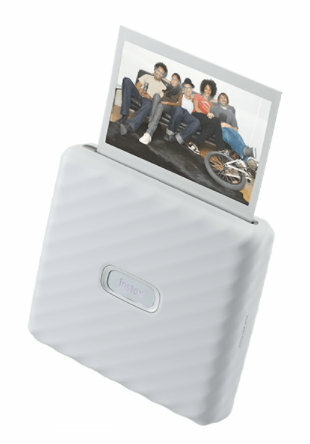 Przenośna drukarka zdjęć, z której wyrzucane jest wydrukowane zdjęcie.