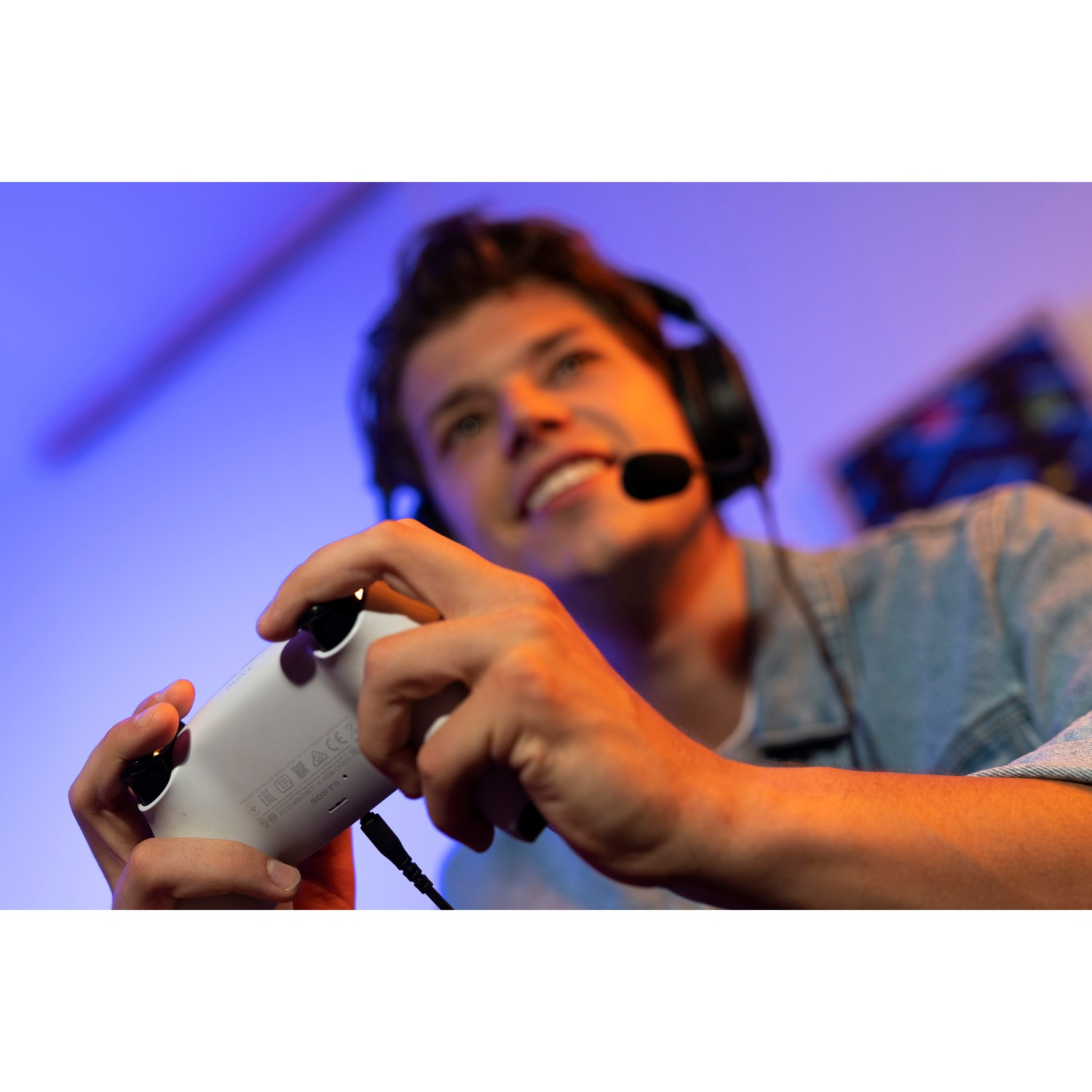 Smiling man wearing headset and holding a white game controller.
