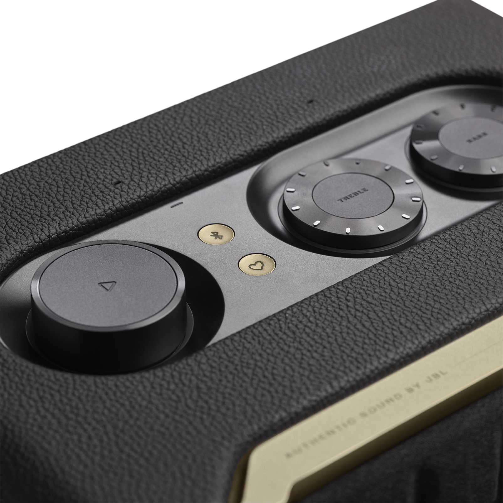 Enceinte noire avec des accents métalliques. Comporte des boutons de volume et de contrôle. Logo JBL.