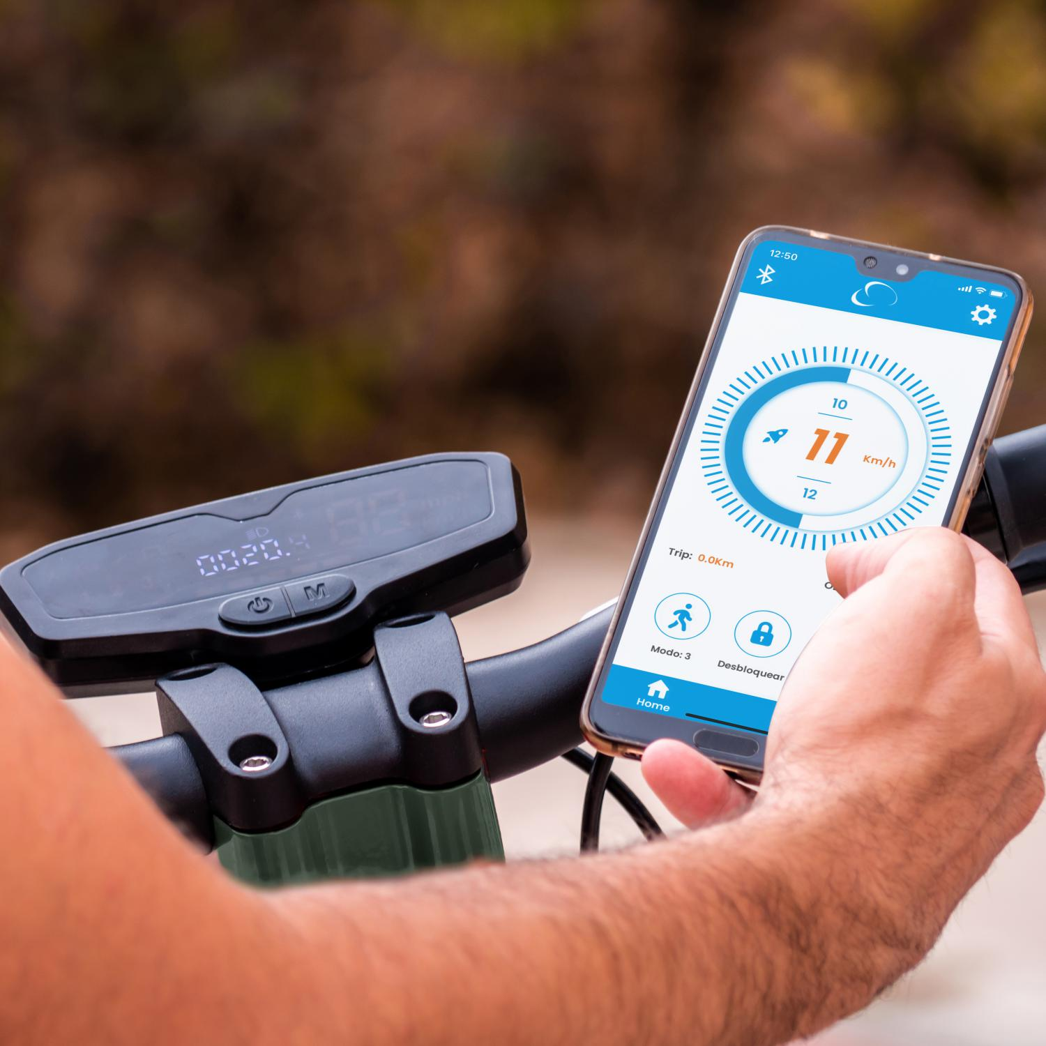 Una persona sosteniendo un teléfono que muestra la velocidad de un scooter eléctrico y otros datos.