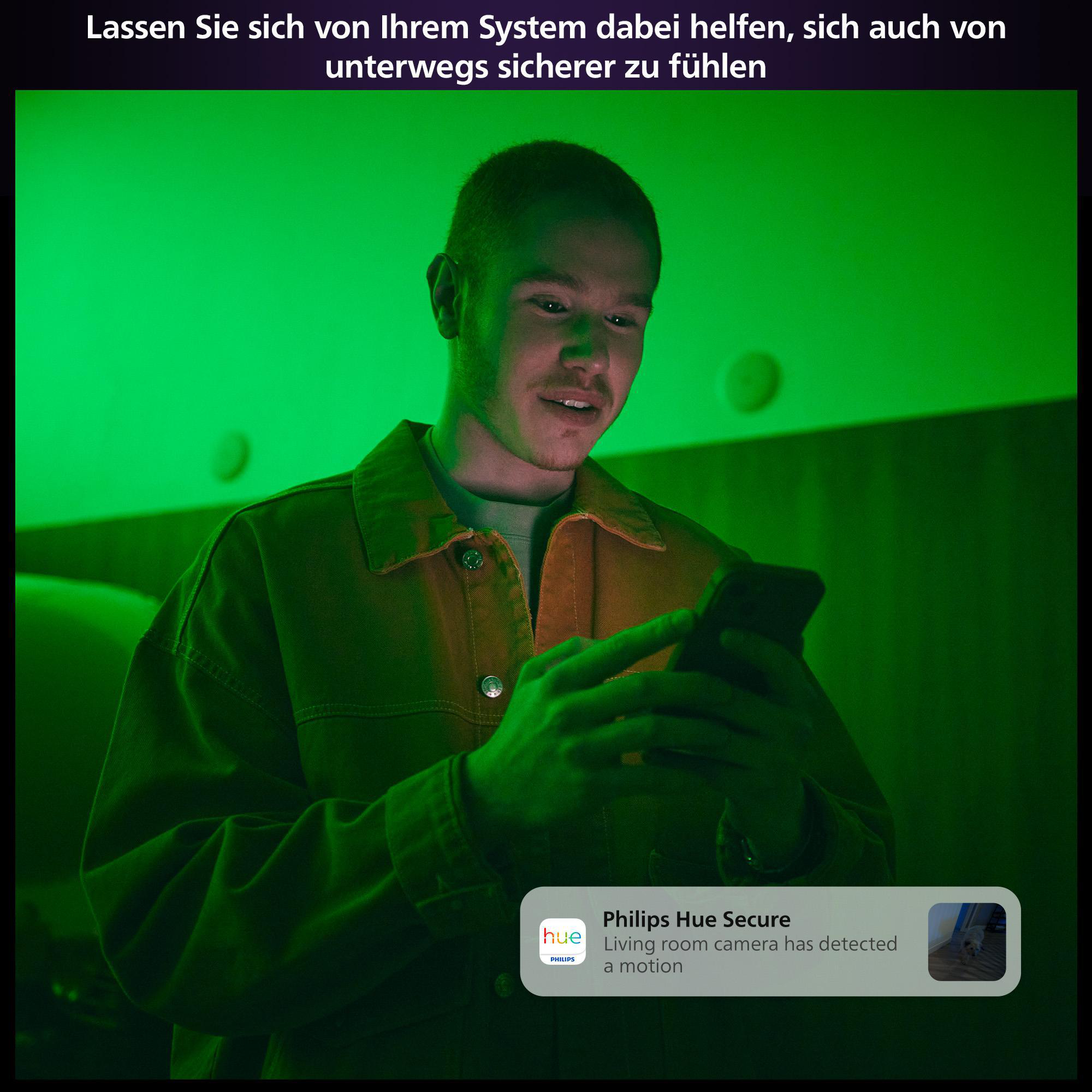 Mann schaut auf ein Telefon mit Sicherheitsbenachrichtigung. Grüne Beleuchtung im Hintergrund.