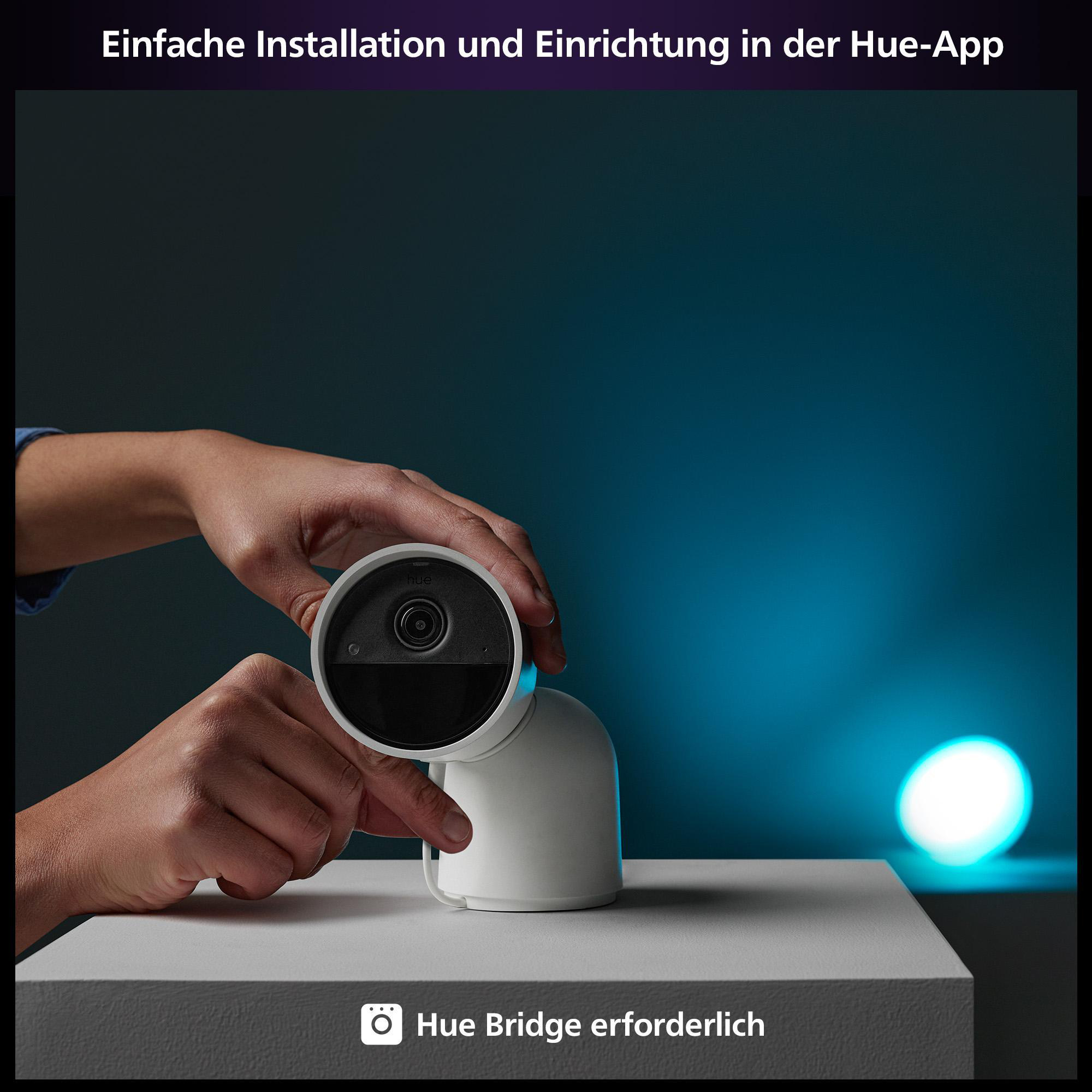 Hände installieren eine weiße Überwachungskamera auf weißer Oberfläche, blaues Licht.