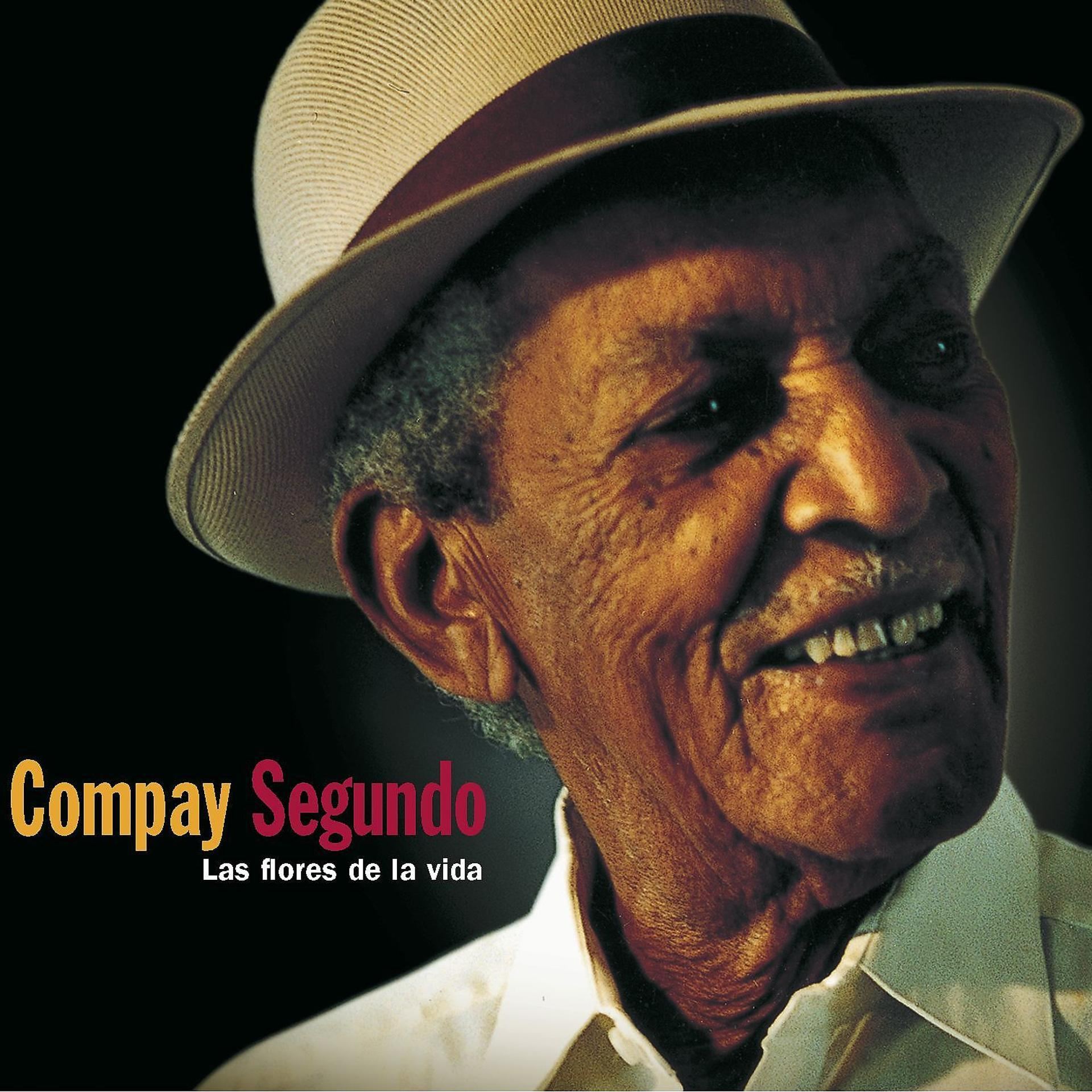 Compay Segundo portréja kalapban, mosolyogva. A szöveg: "Compay Segundo" és "Las flores de la vida".