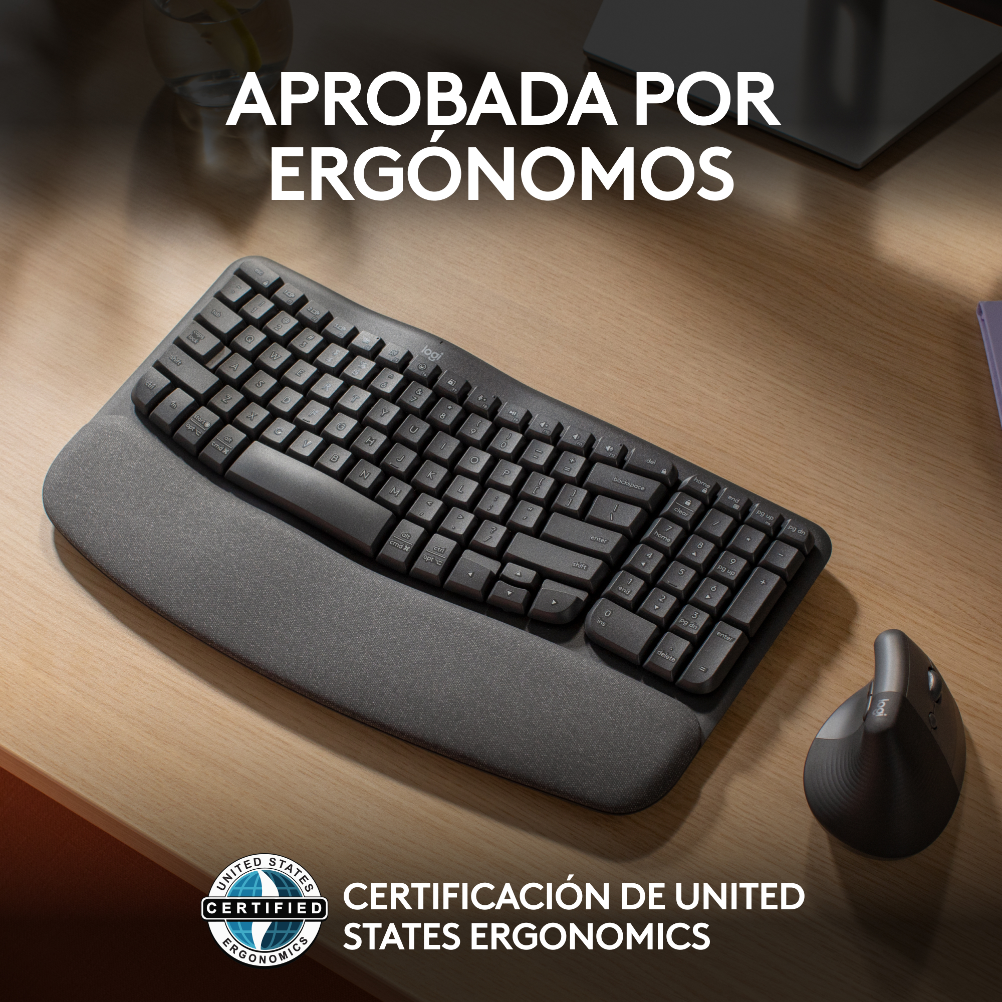 Teclado y ratón ergonómicos en escritorio de madera, texto 'APROBADA POR ERGONOMOS'.