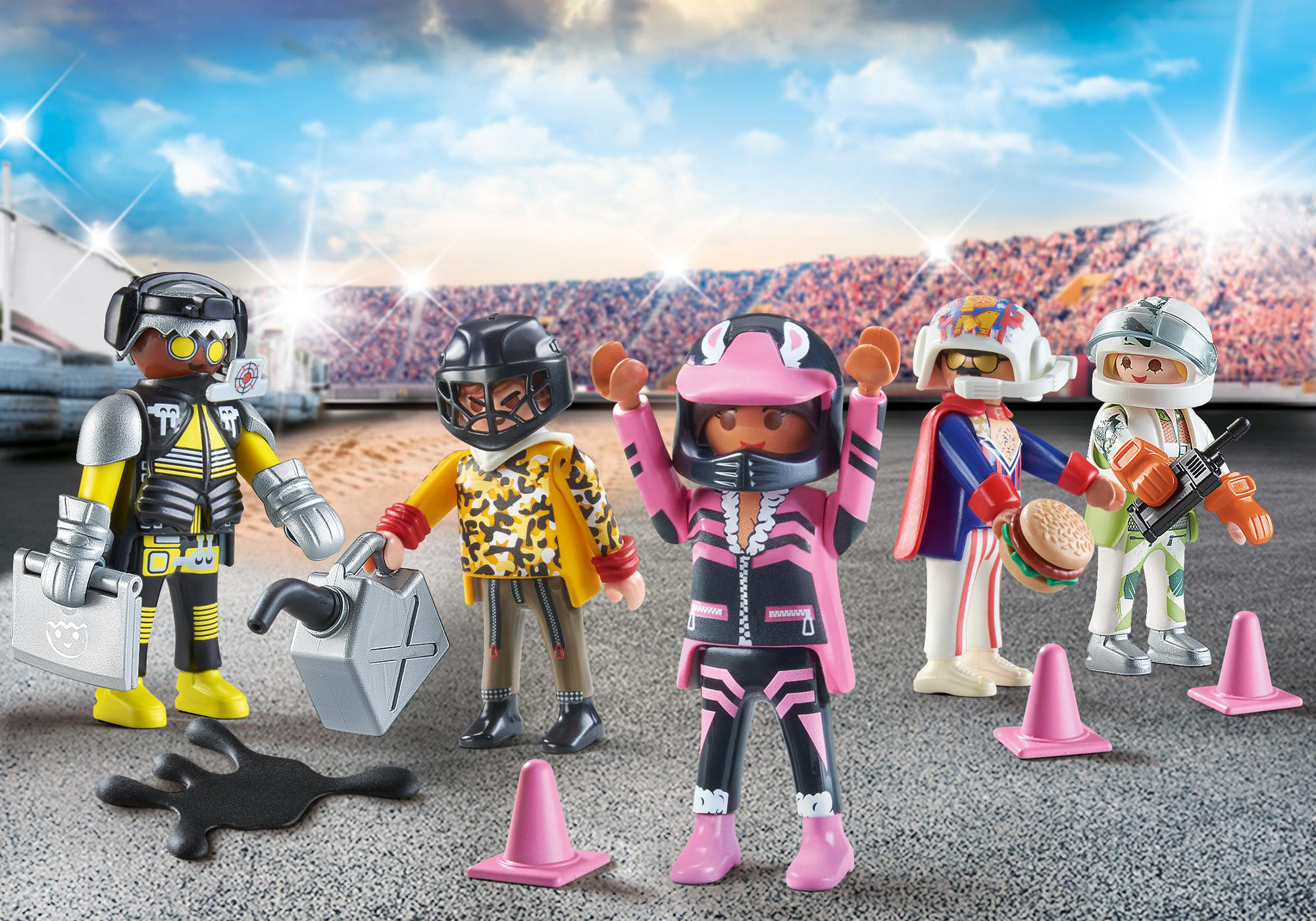 Sechs Playmobil-Figuren in Rennkleidung. Einige halten Werkzeuge, andere heben die Hände. Pinke Kegel und Rennstrecke im Hintergrund.