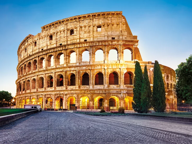 Il Colosseo a Roma, un grande anfiteatro antico, sotto un cielo blu.